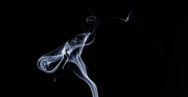 A wisp of smoke against a black background