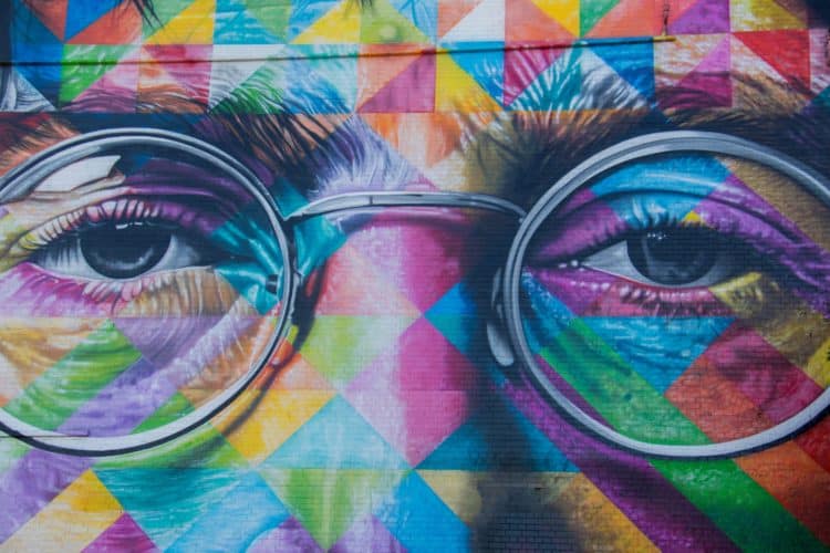 Colorful mural of the eyes and glasses of John Lennon of the Beatles on a brick wall in the United Kingdom